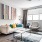 1 Bedroom Apartments in Union Hill, Kansas City, MO - Gallerie Apartments - Furnished Living Room with a Large Window, Light Sofa, Armchair, Coffee Table, and Wood-Style Flooring