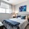 One Bedroom Apartments in Union Hill, Kansas City, MO - Gallerie Apartments - Carpeted Bedroom with a Bed, Nightstands, Lamps, Wooden Dresser, and a Large Window