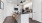 Two Bedroom Apartments in Union Hill, Kansas City, MO - Gallerie Apartments - Modern Kitchen with Stainless Steel Appliances, Black Granite Countertops, White Cabinetry, Tile Backsplash, and a Large Cooking Island with Stools and a Sink